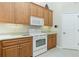 Kitchen features white appliances and light wood cabinets at 437 Loveland Blvd, Port Charlotte, FL 33954