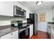 Galley kitchen with stainless steel appliances and granite counters at 4657 Nele St, North Port, FL 34287