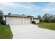 Two-car garage and driveway, manicured lawn at 5435 Montego Ln, Port Charlotte, FL 33981