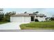 White house with two-car garage and green lawn at 5435 Montego Ln, Port Charlotte, FL 33981