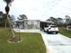 Mobile home exterior features a light green exterior, landscaped yard, and driveway at 5448 Joy Ct, North Port, FL 34287