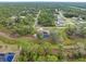 Aerial view of a single-Gathering home with solar panels and a pool in a wooded area at 5465 Trumpet St, North Port, FL 34291