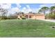 Single-story home with a light peach exterior and landscaped lawn at 5465 Trumpet St, North Port, FL 34291