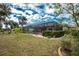 Landscaped backyard with a large screened pool and patio at 594 Rotonda Cir, Rotonda West, FL 33947