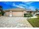 Two-car garage home with paver driveway and landscaping at 594 Rotonda Cir, Rotonda West, FL 33947