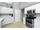 Well-equipped kitchen, featuring stainless steel appliances and white cabinetry at 594 Rotonda Cir, Rotonda West, FL 33947