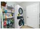 Laundry room with stackable washer and dryer and storage shelving at 594 Rotonda Cir, Rotonda West, FL 33947