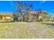 Tan house with red tile roof and landscaping, showcasing the side yard at 7148 & 7140 Coventry Ter, Englewood, FL 34224