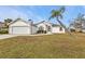 Front yard view of a single-story house with a palm tree at 87 Torrington St, Port Charlotte, FL 33954