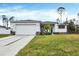 Single-story home with a two-car garage and landscaped lawn at 99 Sundiet St, Port Charlotte, FL 33954