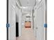 A hallway view of the bathroom showcases a dual sink vanity, a tub, and a glass shower door at 10501 Amberjack Way # 101, Englewood, FL 34224