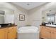 Elegant bathroom with a large soaking tub and dual vanities with granite counters at 10501 Amberjack Way # 101, Englewood, FL 34224