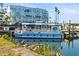 A waterfront view of Gasparilla Boat Tours docked near a multi-story residence with palm trees at 10501 Amberjack Way # 101, Englewood, FL 34224