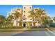 Stunning view of a condo building with a well-manicured lawn and beautiful palm trees around at 10501 Amberjack Way # 101, Englewood, FL 34224