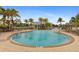 Large community pool surrounded by lounge chairs and palm trees, creating a resort-like atmosphere at 10501 Amberjack Way # 101, Englewood, FL 34224