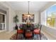 Bright dining room featuring modern light fixture, round table, and large window with natural light at 10501 Amberjack Way # 101, Englewood, FL 34224