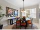 Dining room with a round table, six chairs, modern lighting, and decor against light-colored walls at 10501 Amberjack Way # 101, Englewood, FL 34224