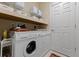 The practical laundry area includes a side by side washer and dryer with storage shelves above at 10501 Amberjack Way # 101, Englewood, FL 34224