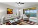 Bright living room with modern furniture, ceiling fan, and glass doors to screened balcony at 10501 Amberjack Way # 101, Englewood, FL 34224
