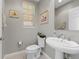 Powder room featuring a pedestal sink, toilet, and artwork on the wall at 10501 Amberjack Way # 101, Englewood, FL 34224