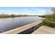 A serene water view from a boardwalk's wooden dock, showcasing a beautiful landscape at 10501 Amberjack Way # 101, Englewood, FL 34224
