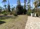 Large backyard with partially paved patio and mature trees at 1209 Nordendale Blvd, North Port, FL 34288