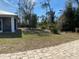 Large backyard with mature trees and partially paved patio at 1209 Nordendale Blvd, North Port, FL 34288
