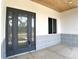 Modern front entry with gray door and wood ceiling at 1209 Nordendale Blvd, North Port, FL 34288