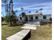 Contemporary house with metal roof, light gray accents, and steps leading to the entrance at 1209 Nordendale Blvd, North Port, FL 34288