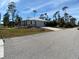 Modern house with metal roof, light gray accents, and driveway at 1209 Nordendale Blvd, North Port, FL 34288