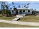Modern house with metal roof, light gray accents, and steps leading to the entrance at 1209 Nordendale Blvd, North Port, FL 34288