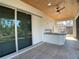 Covered patio with outdoor kitchen featuring a built-in bar and ceiling fan at 1209 Nordendale Blvd, North Port, FL 34288