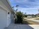 Side yard view with paved driveway and a green bush at 1209 Nordendale Blvd, North Port, FL 34288