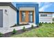 Modern home with a blue and white exterior, a wooden door, and landscaped walkway at 15133 Amsterdam, Port Charlotte, FL 33981