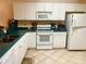Condo kitchen with white cabinets, teal countertops, and modern appliances at 175 Kings Hwy # Bldg 3 314, Punta Gorda, FL 33983