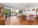 Living room with hardwood floors, balcony access, and a pink chair at 1801 Jamaica Way # 112, Punta Gorda, FL 33950