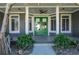 Green double doors and a covered porch with wood-look tile floor at 2329 Pinellas Dr, Punta Gorda, FL 33983