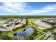 Aerial view of houses, golf course, and ponds in a lush green community at 25187 Keygrass Ct, Punta Gorda, FL 33955