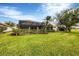 Spacious backyard with manicured lawn, enclosed pool, and lush green privacy hedge at 25187 Keygrass Ct, Punta Gorda, FL 33955