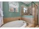 Soaking tub surrounded by tile, complemented by a separate glass-enclosed shower, and a decorative window at 25187 Keygrass Ct, Punta Gorda, FL 33955