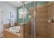 Bathroom featuring a soaking tub, and separate shower, with neutral tiles and a decorative window at 25187 Keygrass Ct, Punta Gorda, FL 33955