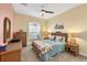 Bright bedroom with tropical themed decor, including wicker furniture, colorful bedding, and a ceiling fan at 25187 Keygrass Ct, Punta Gorda, FL 33955