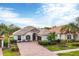 Charming one-story home featuring a tile roof, landscaped yard, and brick driveway at 25187 Keygrass Ct, Punta Gorda, FL 33955