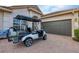 Golf cart parked in front of a house with a brick driveway and a two-car garage at 25187 Keygrass Ct, Punta Gorda, FL 33955