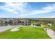 Scenic view of the golf course featuring a well-kept green, sand trap, and serene water views at 25187 Keygrass Ct, Punta Gorda, FL 33955
