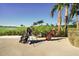 Scenic golf course view with two golf bags on the grounds, set against lush greenery and clear blue skies at 25187 Keygrass Ct, Punta Gorda, FL 33955