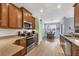 Modern kitchen with wooden cabinets, granite countertops, and stainless-steel appliances with an adjoining dining area at 25187 Keygrass Ct, Punta Gorda, FL 33955