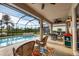 Screened patio with a pool, spa, dining area, ceiling fans, and comfortable seating at 25187 Keygrass Ct, Punta Gorda, FL 33955