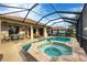 Screened-in pool and spa featuring a brick-laid border, conveniently accessible with a handrail at 25187 Keygrass Ct, Punta Gorda, FL 33955