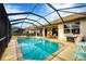 Enclosed pool and spa with outdoor seating and grilling area under covered lanai at 25187 Keygrass Ct, Punta Gorda, FL 33955